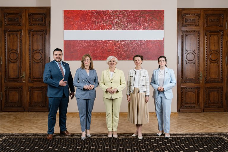 Pieci 14. Saeimas Prezidija locekļi stāv blakus cits citam Saeimas ēkā. No kreisās: Saeimas sekretārs Jānis Grasbergs, Saeimas priekšsēdētājas biedre Zanda Kalniņa-Lukaševica, Saeimas priekšsēdētāja Daiga Mieriņa, Saeimas priekšsēdētājas biedre Linda Matisone un Saeimas sekretāra biedre Antoņina Ņenaševa.